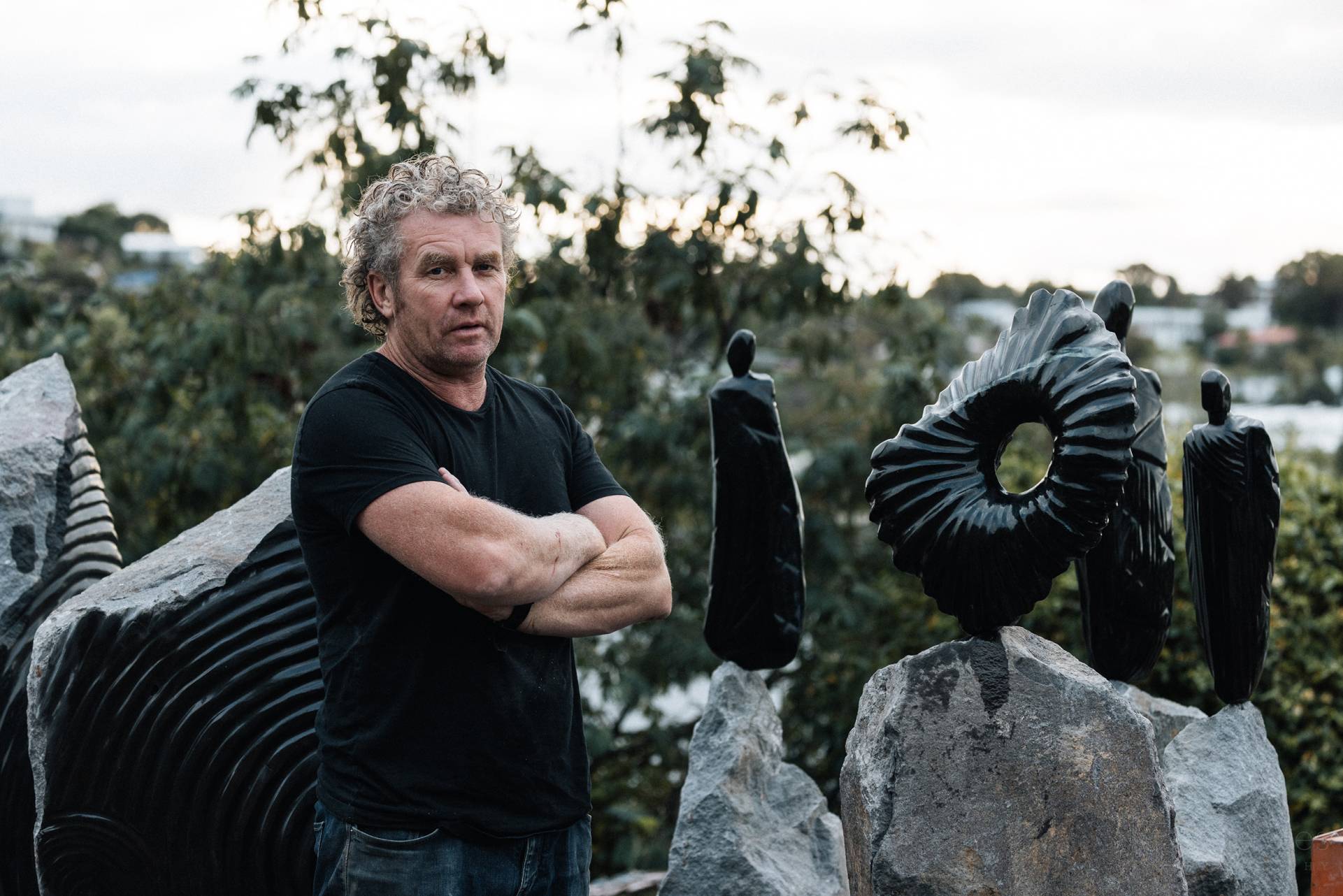 Anton Forde  standing amongst his sculpture, Te Kotahitanga o Whakamaru. Sculpture on the Gulf Runner Up People's Choice, 2022